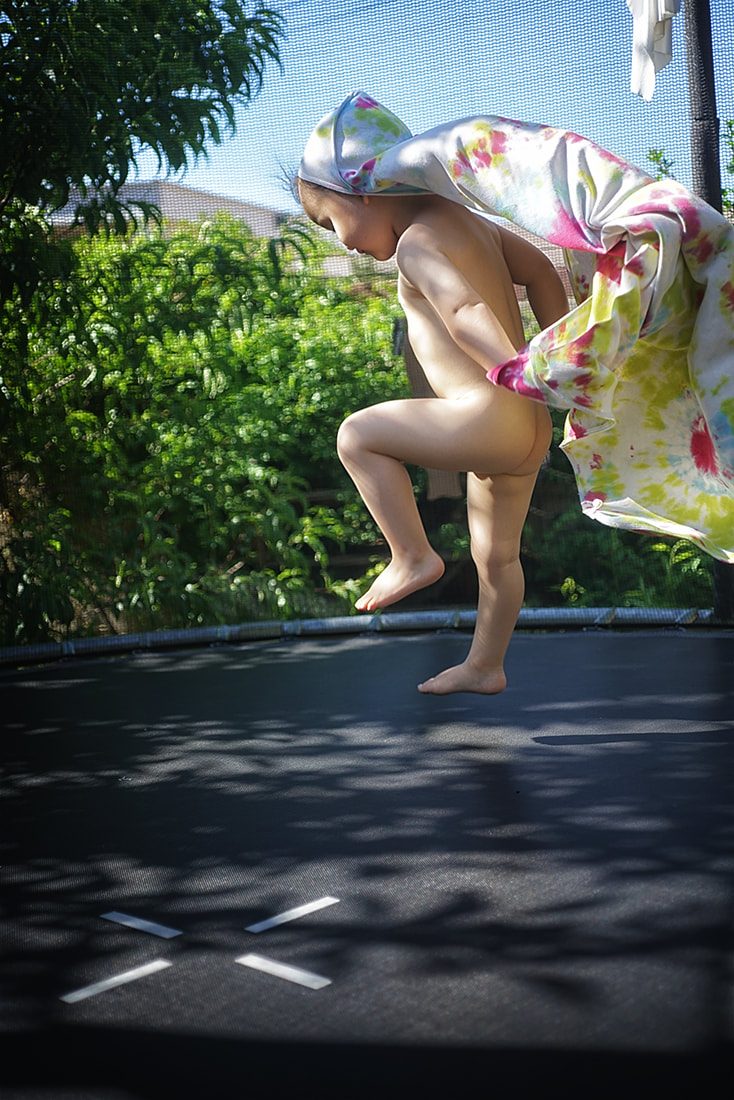 boy jumping on trampoline in towel