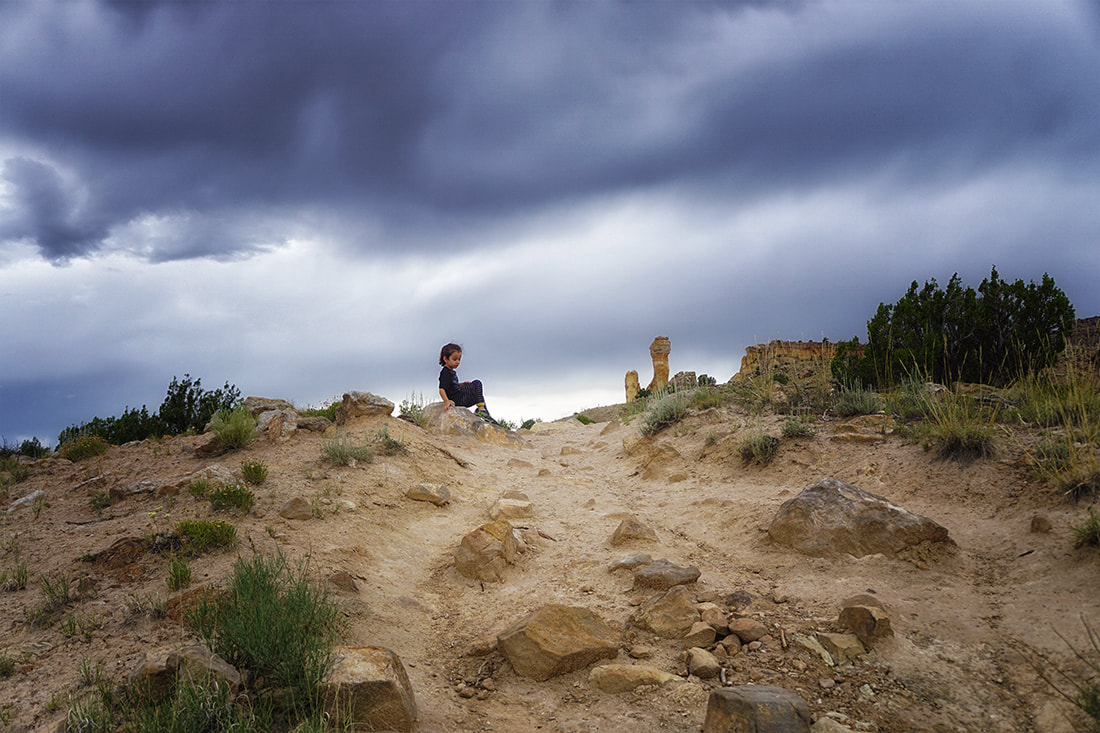 Boy rests on trail to chimney rock, Ghost Ranch, New Mexico
