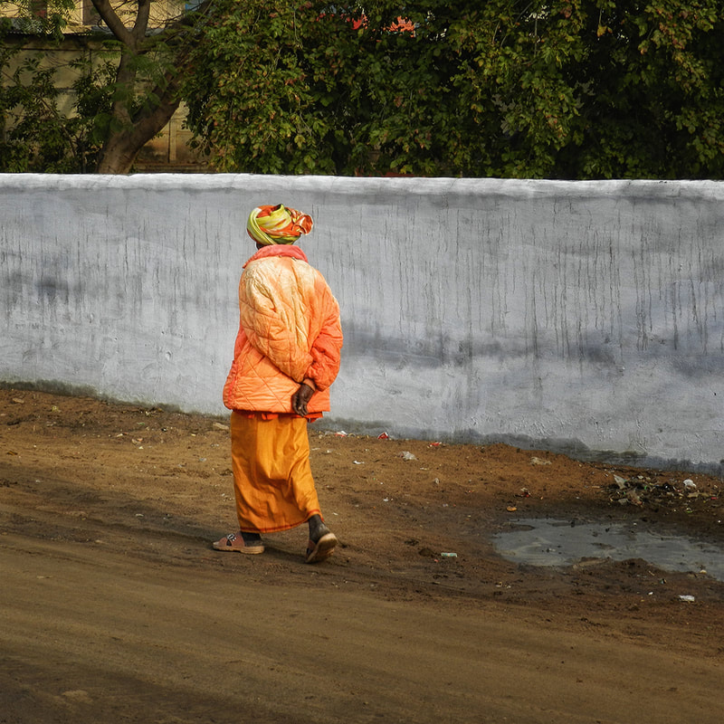 Solitary Man in Orange Walks Along Road, Pushkar, Rajasthan, India